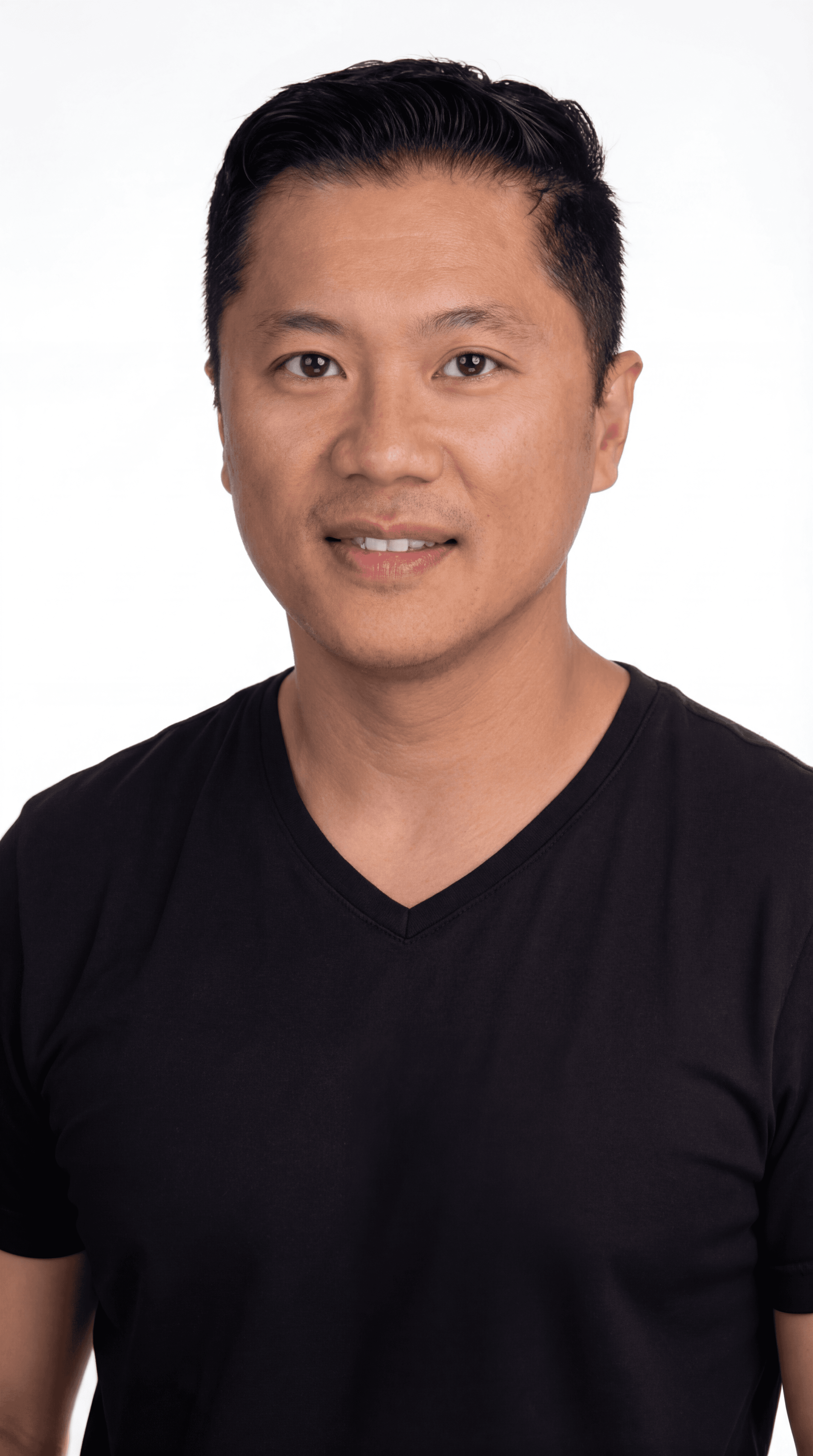Headshot of a smiling man with short dark hair wearing a black V-neck t-shirt.